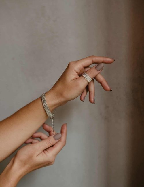hands on gray background with handmade jewelry hands on gray background with handmade jewelry